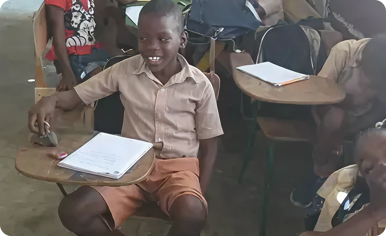 Student sitting at wooden desk, smiling